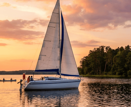White sailing yacht on a calm lake at sunset